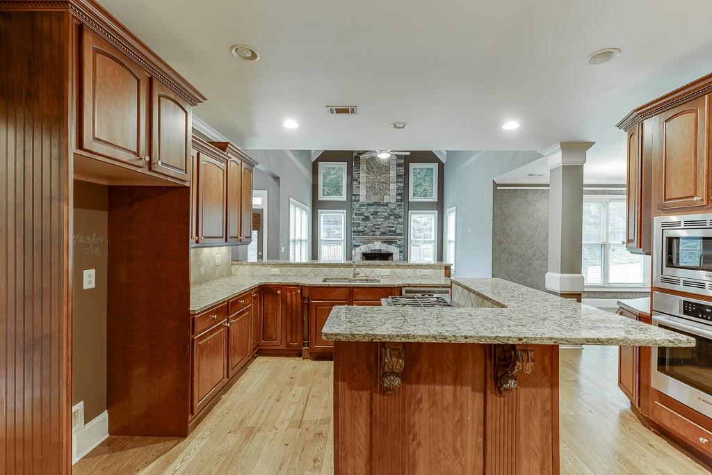 940 Chateau Forest Road Hoschton, GA 30548 - Photo 25 of 87 a kitchen with stainless steel appliances granite countertop a sink stove and refrigerator