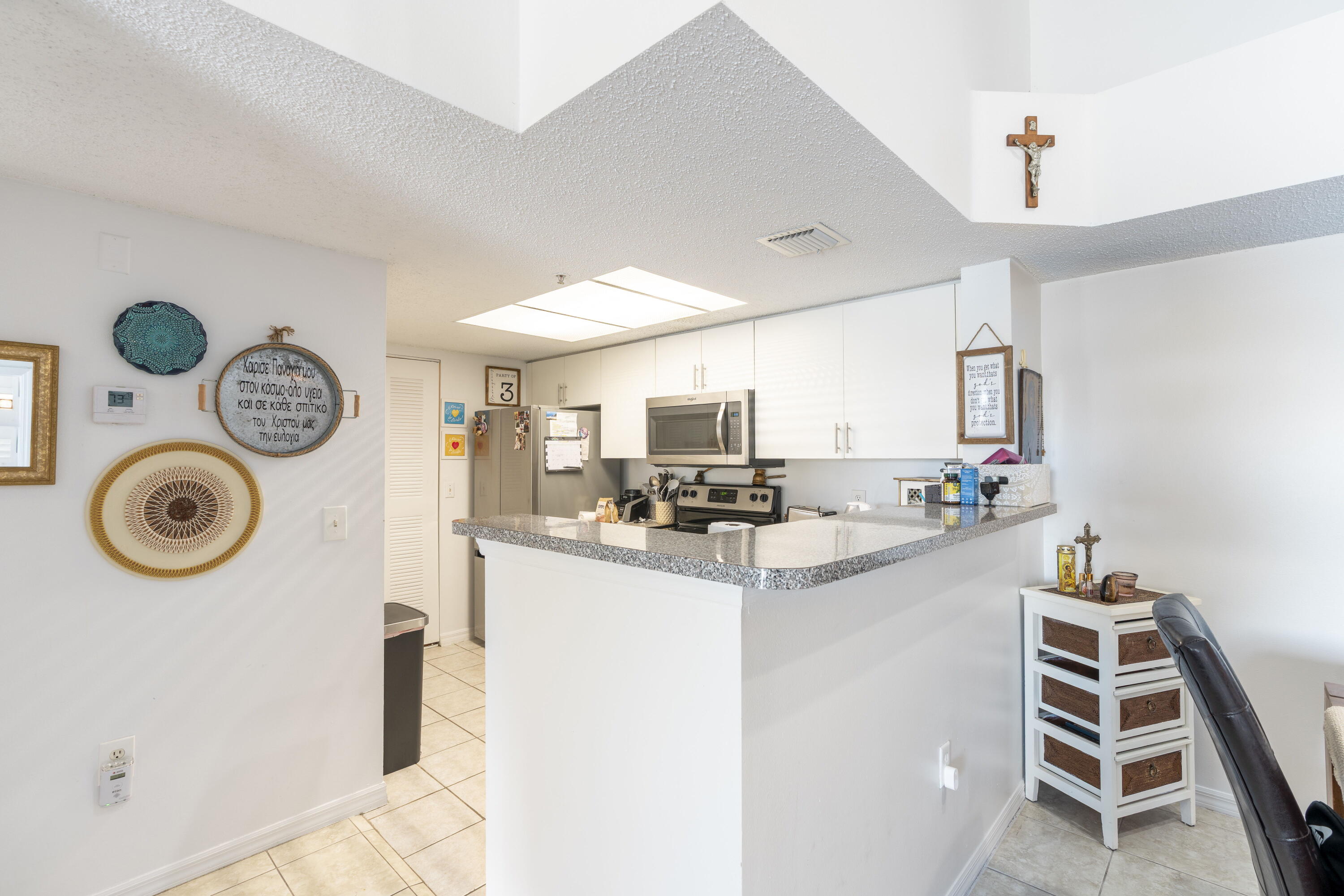 5031 Wiles Road, Unit 304 Coconut Creek, FL 33073 - Photo 22 of 55 a kitchen with kitchen island sink stove and cabinets