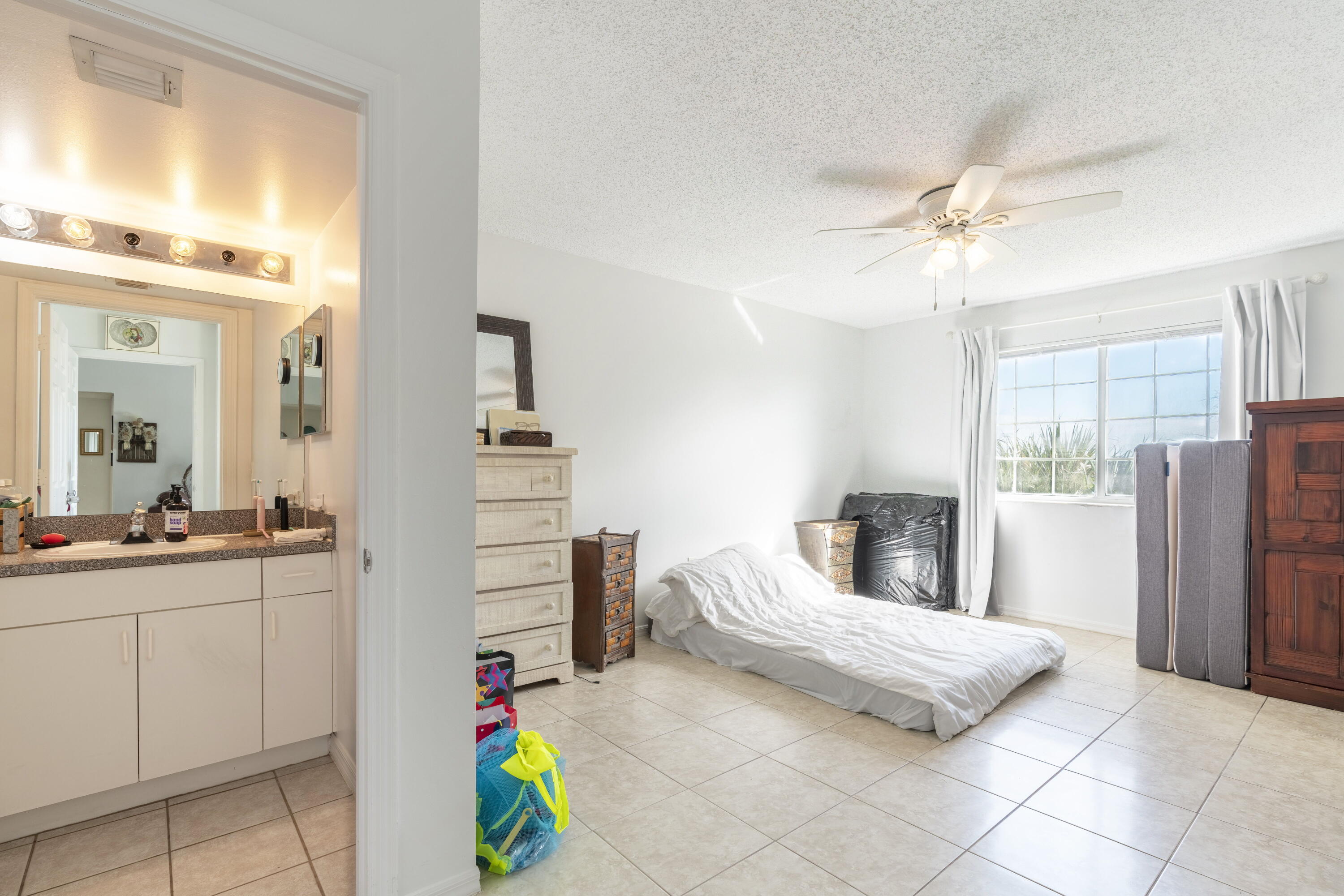 5031 Wiles Road, Unit 304 Coconut Creek, FL 33073 - Photo 32 of 55 a bedroom with a bed and a chandelier