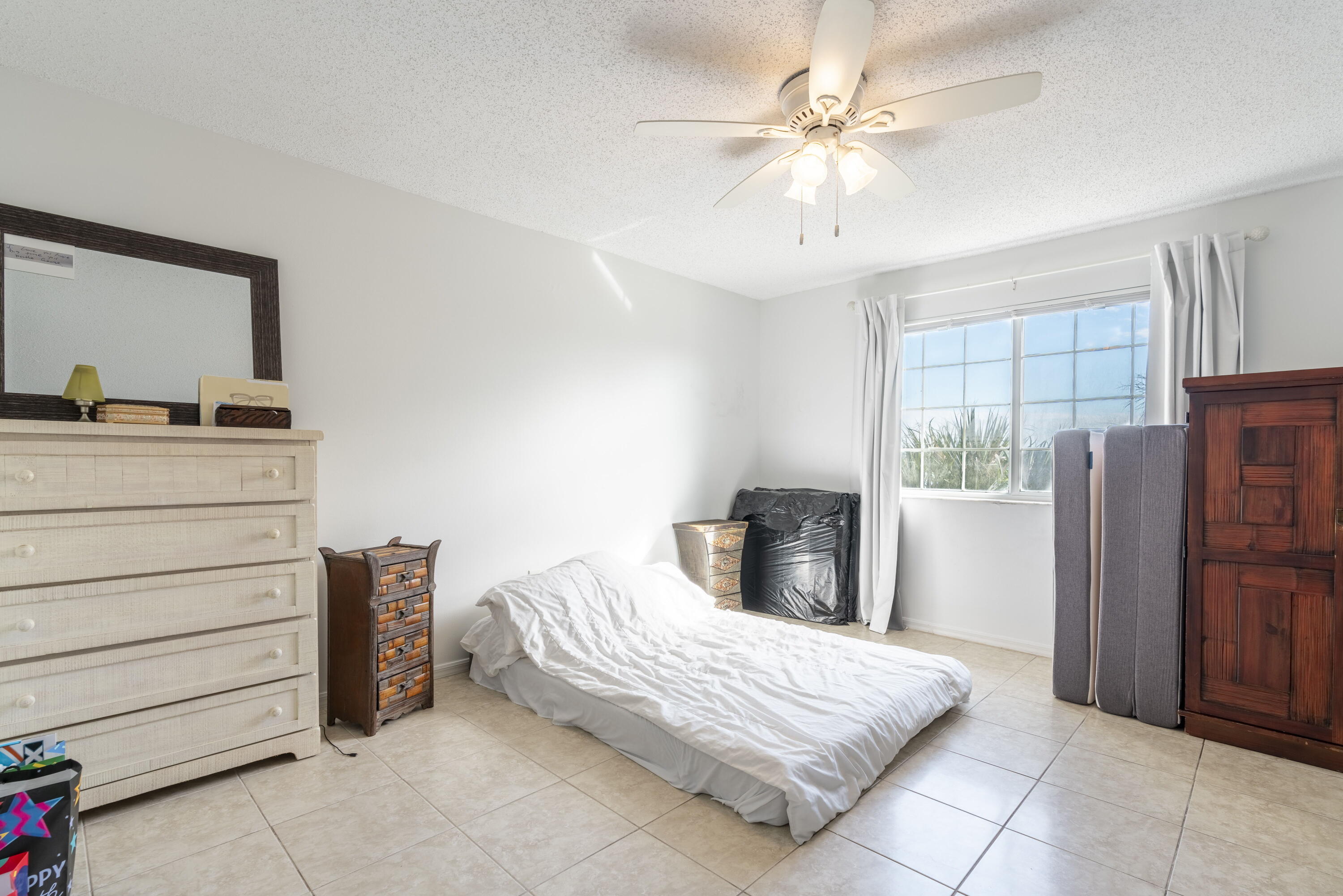 5031 Wiles Road, Unit 304 Coconut Creek, FL 33073 - Photo 33 of 55 a bedroom with a bed and a dresser