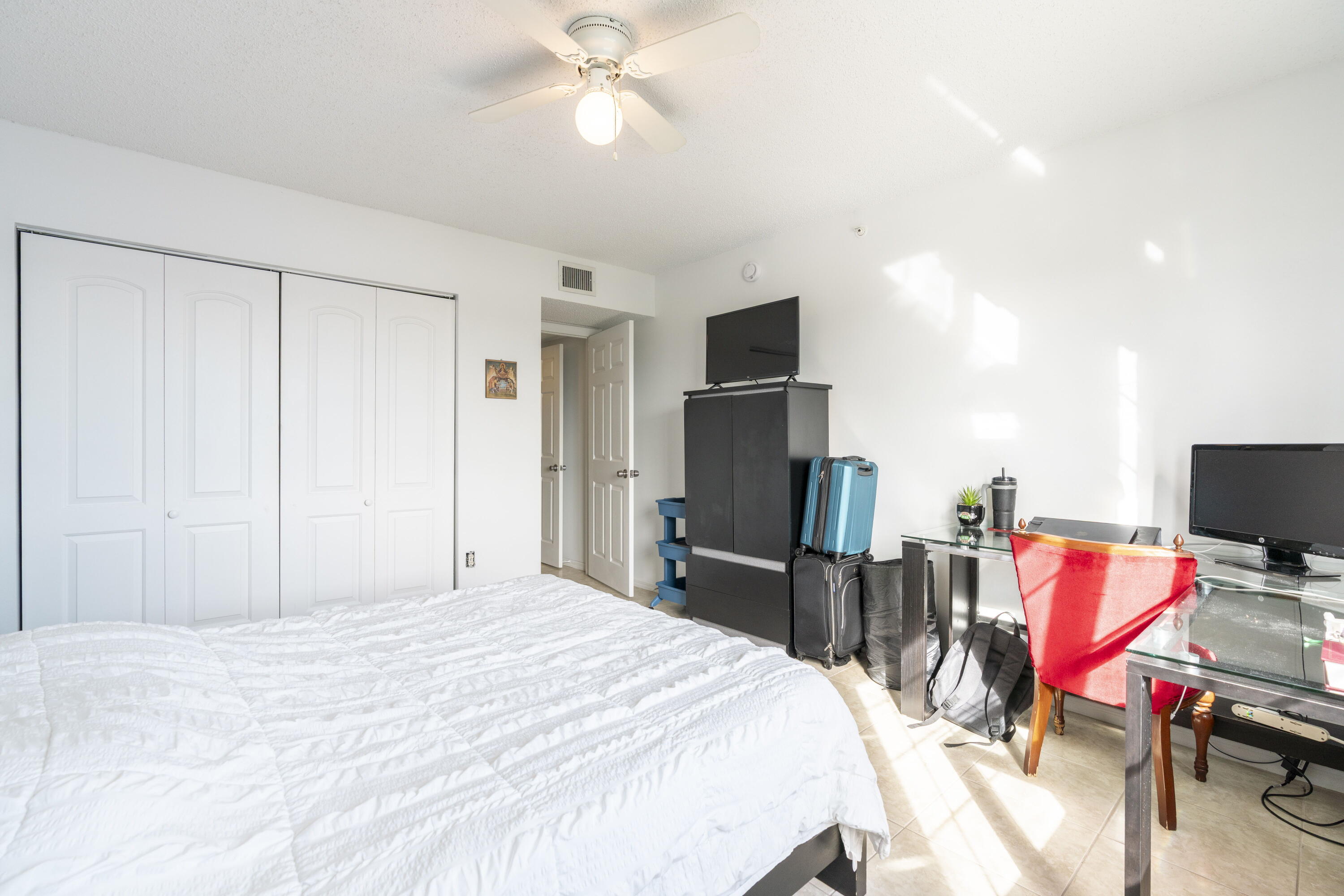 5031 Wiles Road, Unit 304 Coconut Creek, FL 33073 - Photo 44 of 55 a bedroom with a bed and a flat screen tv