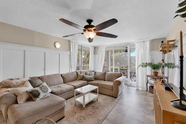 a living room with furniture ceiling fan and a rug