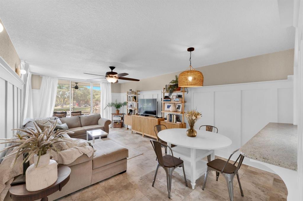 9330 Lagoon Place, Unit 209 Davie, FL 33324 - Photo 4 of 14 a living room with furniture and a chandelier