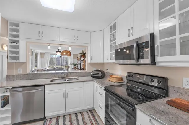 a kitchen with stainless steel appliances a sink stove and cabinets