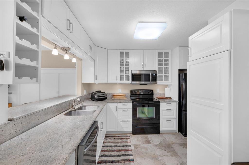 9330 Lagoon Place, Unit 209 Davie, FL 33324 - Photo 6 of 14 a kitchen with stainless steel appliances granite countertop a sink stove and refrigerator