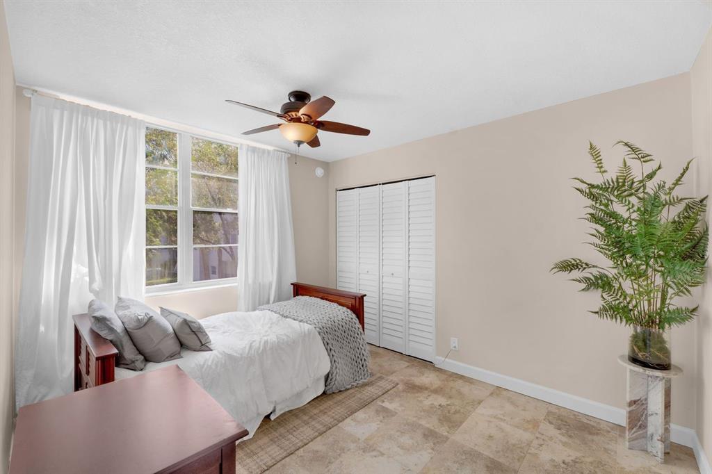 9330 Lagoon Place, Unit 209 Davie, FL 33324 - Photo 9 of 14 a bedroom with a large bed and a potted plant