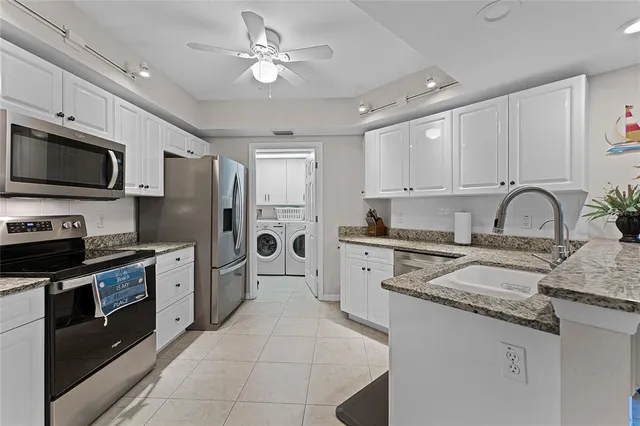 a kitchen with stainless steel appliances granite countertop a stove refrigerator sink and microwave