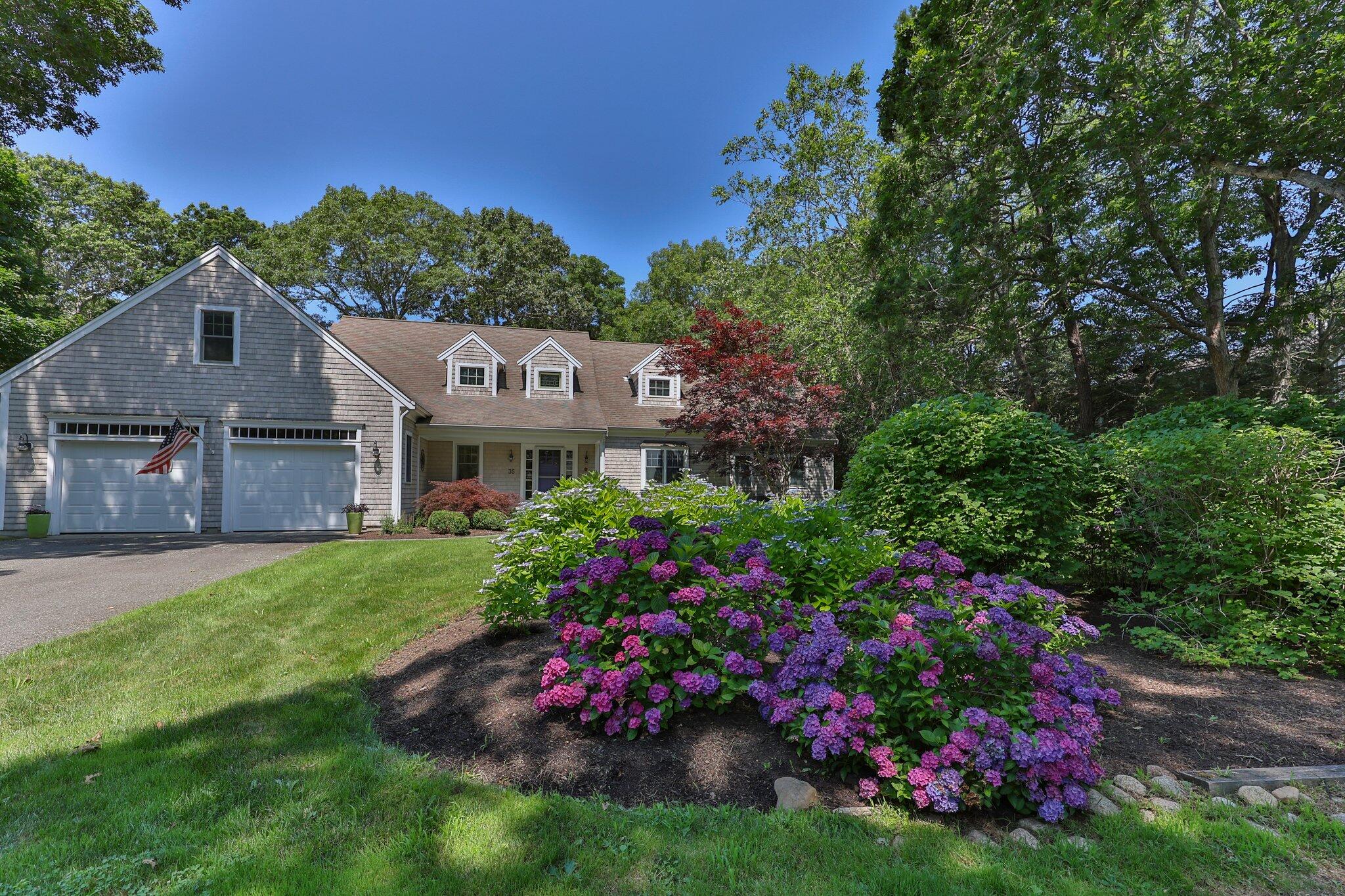 a view of a house with a big yard and potted plants
