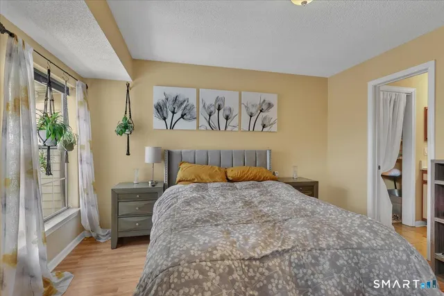 a bedroom with a bed and a painting on the wall