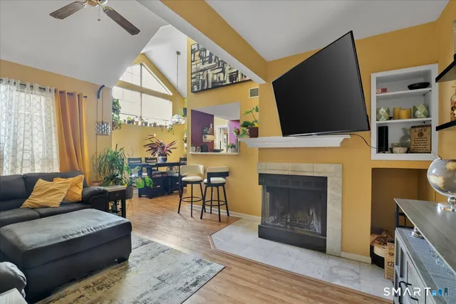 a living room with furniture a flat screen tv and a fireplace