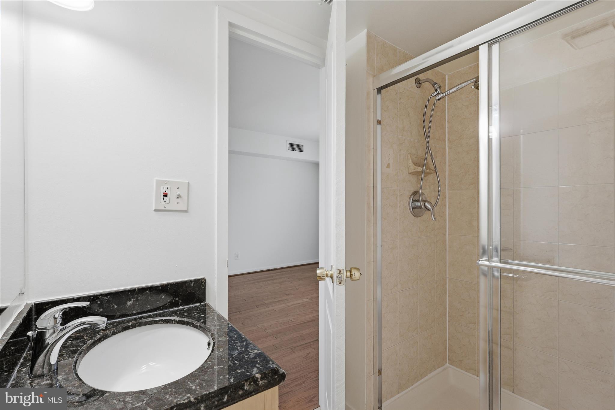 2255 Castle Rock Square, Unit 21C Reston, VA 20191 - Photo 13 of 33 a bathroom with a sink a mirror a lamp and a shower