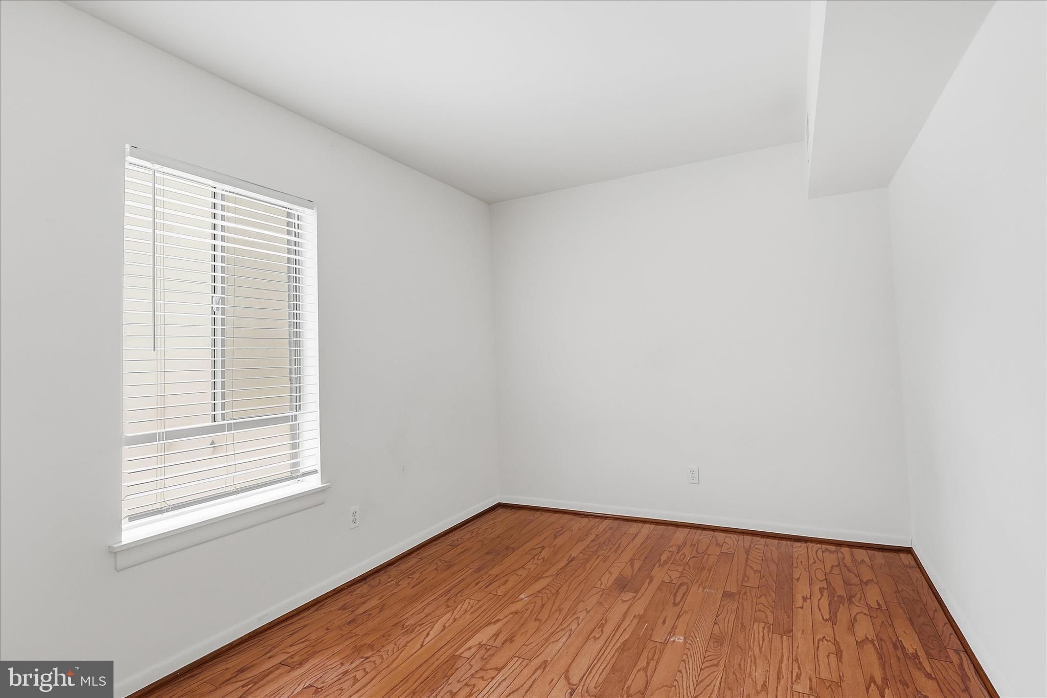 2255 Castle Rock Square, Unit 21C Reston, VA 20191 - Photo 15 of 33 a view of an empty room with wooden floor and a window