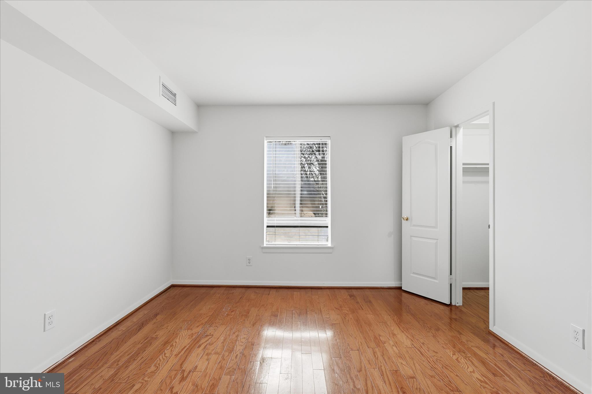 2255 Castle Rock Square, Unit 21C Reston, VA 20191 - Photo 9 of 33 a view of an empty room with wooden floor and a window