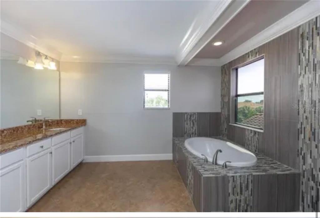 6914 Quiet Creek Drive Bradenton, FL 34212 - Photo 25 of 31 a bathroom with a granite countertop bathtub sink vanity and mirror