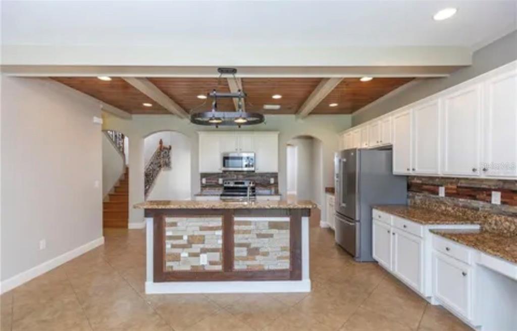 6914 Quiet Creek Drive Bradenton, FL 34212 - Photo 6 of 31 a kitchen with stainless steel appliances granite countertop a lot of counter space and refrigerator