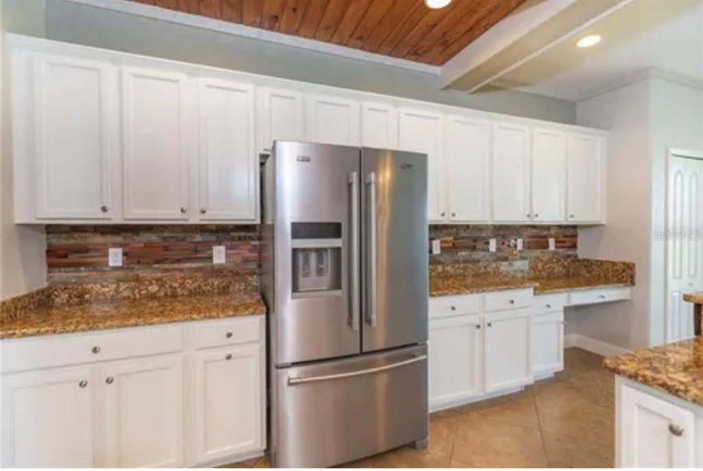 6914 Quiet Creek Drive Bradenton, FL 34212 - Photo 8 of 31 a kitchen with granite countertop a refrigerator and a sink