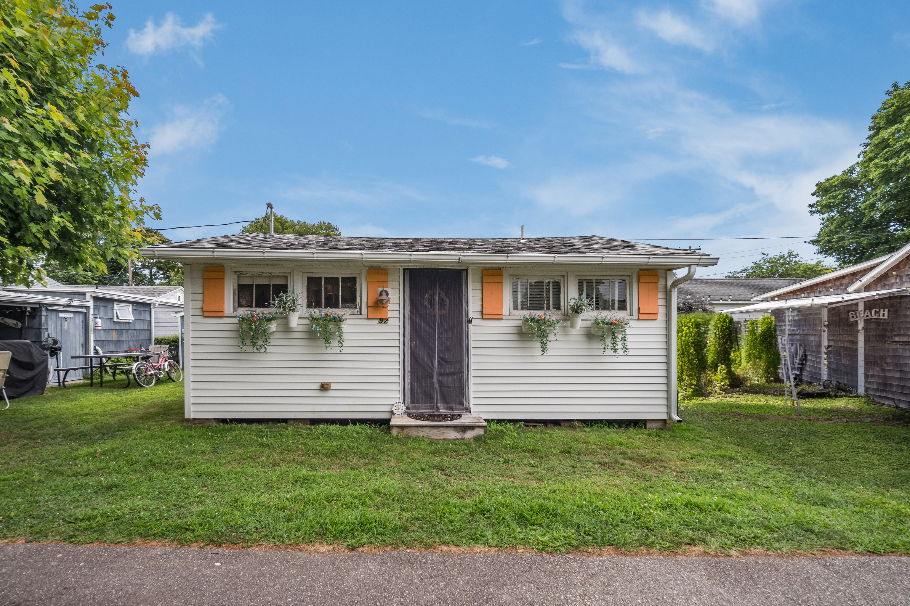 92 4th Avenue Madison, CT 06443 - Photo 14 of 19 a front view of a house with a garden