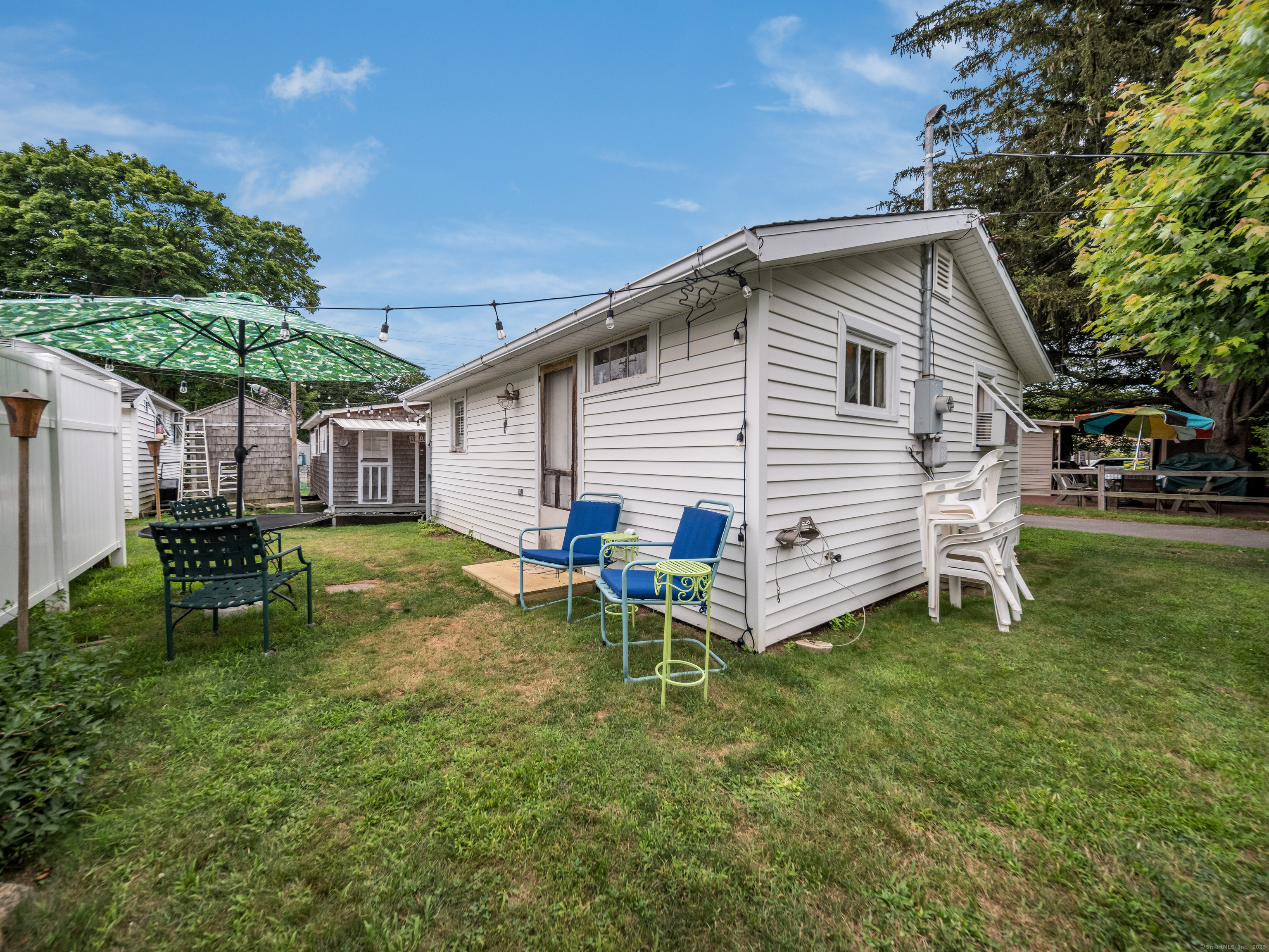 92 4th Avenue Madison, CT 06443 - Photo 18 of 19 a view of a house with a yard chairs and table in a patio