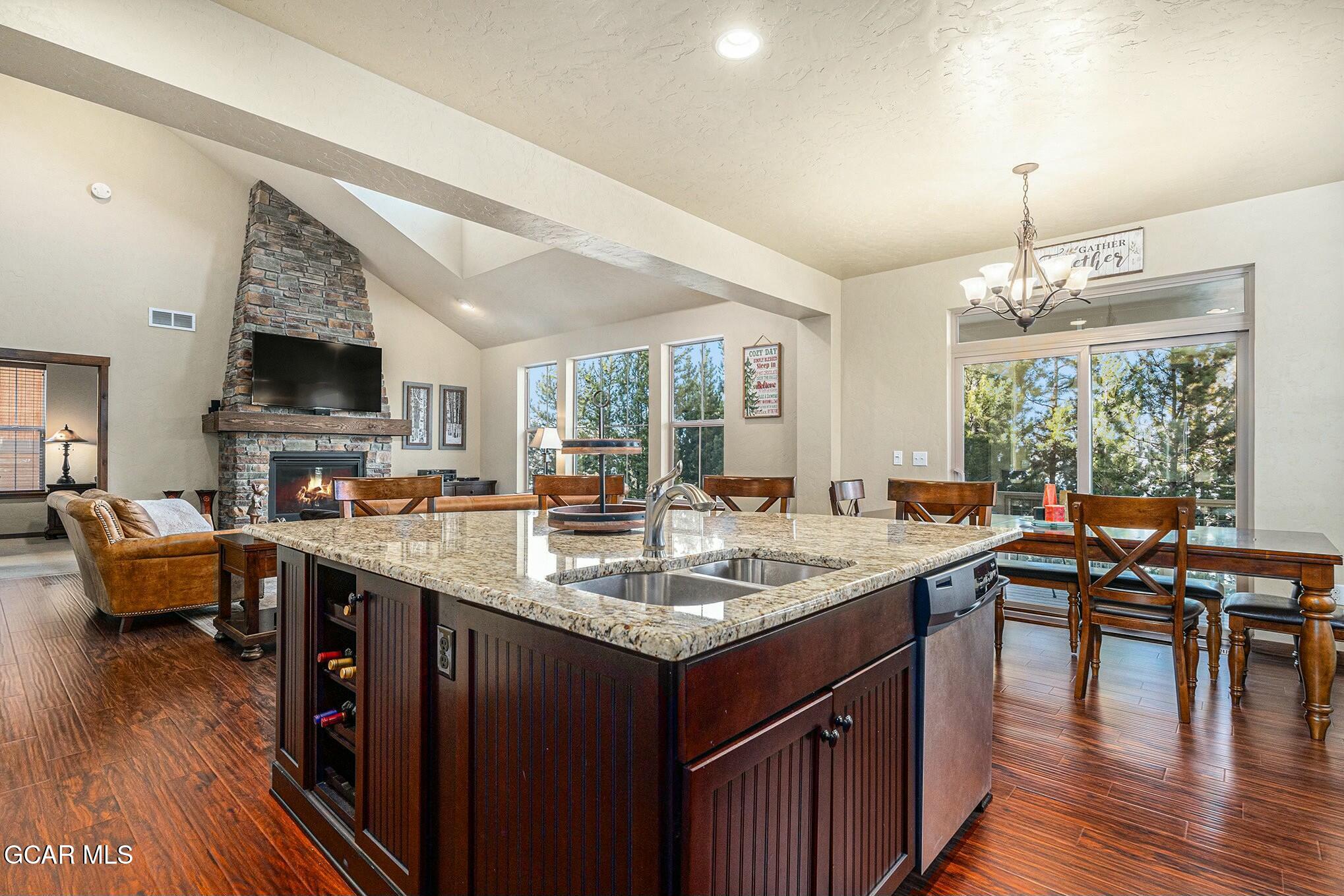 a kitchen with center island wooden floor and a view of living room
