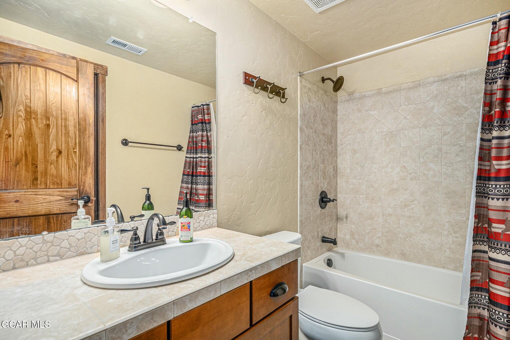 160 First Track Lane Granby, CO 80446 - Photo 25 of 27 a bathroom with a sink a toilet a mirror a bathtub and shower