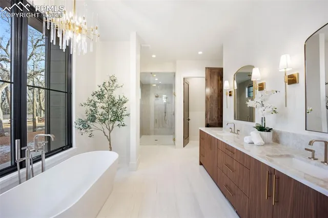 a spacious bathroom with a double vanity sink a large mirror and shower