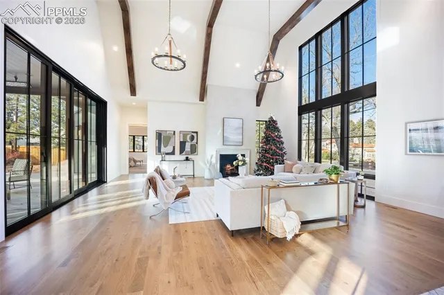 a living room with fireplace furniture wooden floor and a large window