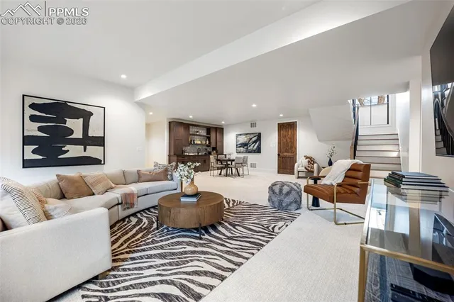 a living room with furniture wooden floor and a large window