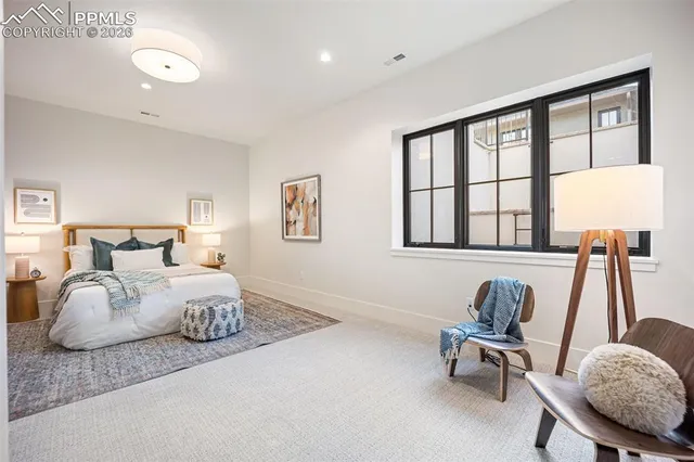 a bedroom with furniture and a large window