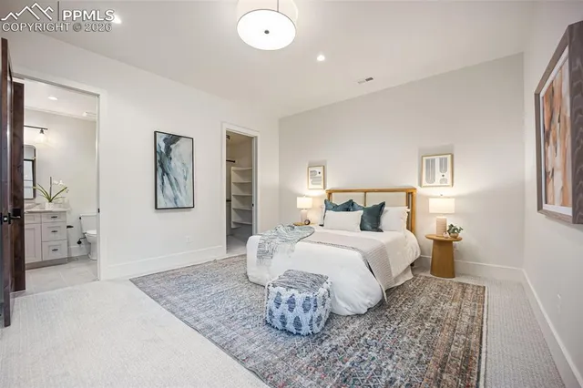 a bedroom with a large bed and a chandelier