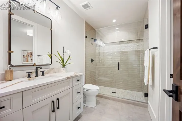 a bathroom with a double vanity sink toilet and shower