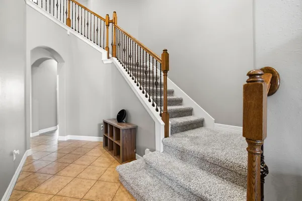 a kitchen with granite countertop a refrigerator a stove top oven and sink