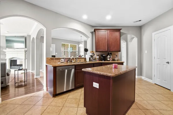 a kitchen with stainless steel appliances granite countertop a refrigerator a stove a sink and a microwave