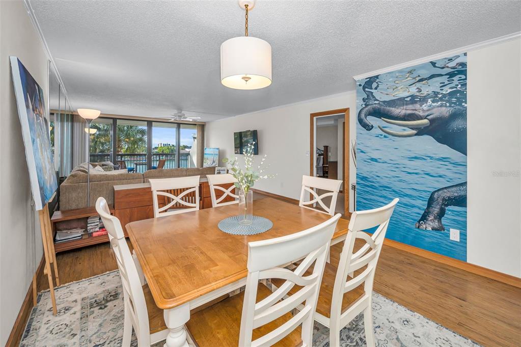 9495 Blind Pass Road, Unit 205 St. Pete Beach, FL 33706 - Photo 24 of 71 a dining room with furniture a window and wooden floor