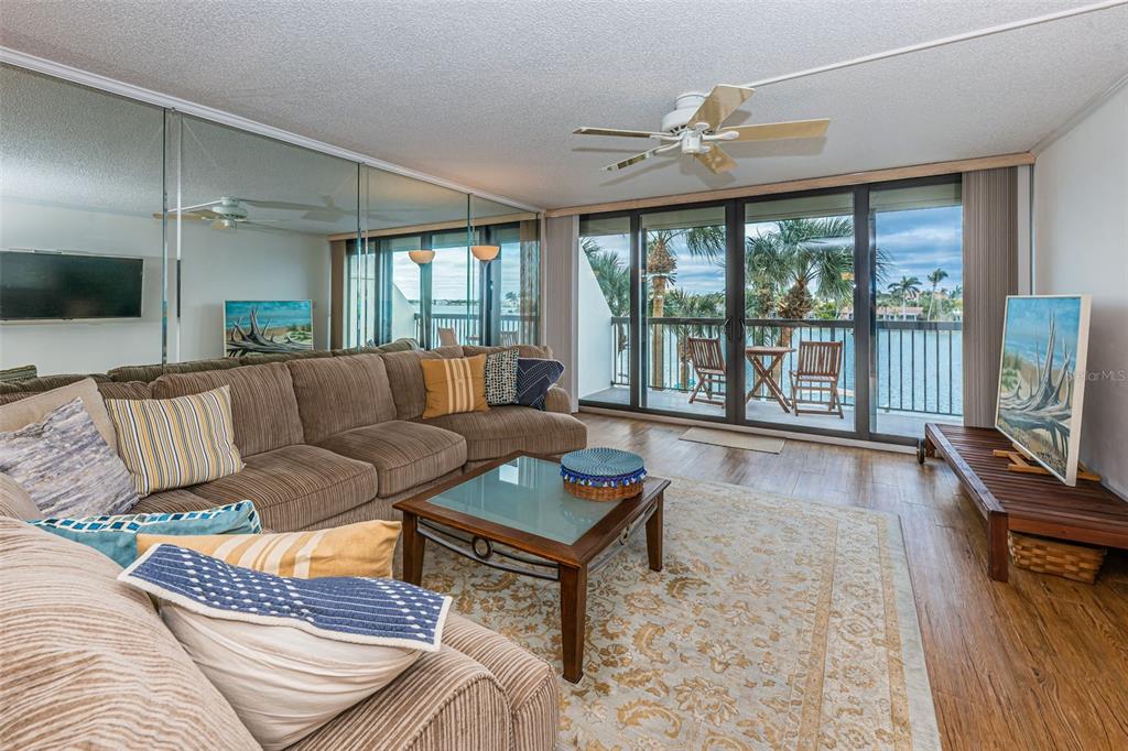 9495 Blind Pass Road, Unit 205 St. Pete Beach, FL 33706 - Photo 27 of 71 a living room with furniture and a flat screen tv