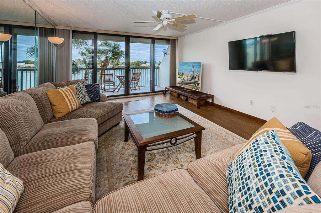 9495 Blind Pass Road, Unit 205 St. Pete Beach, FL 33706 - Photo 28 of 71 a living room with furniture and a flat screen tv