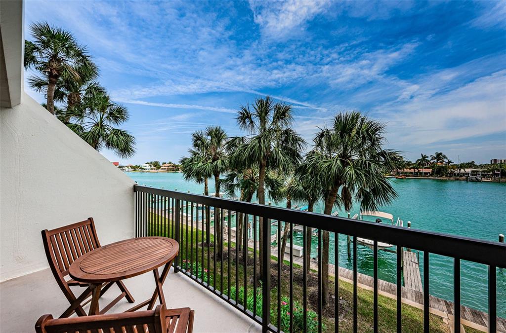 9495 Blind Pass Road, Unit 205 St. Pete Beach, FL 33706 - Photo 34 of 71 a view of a chair and table on the deck