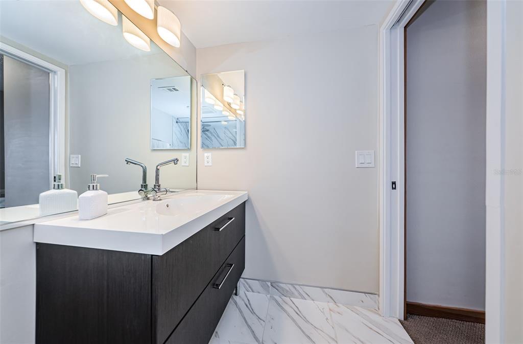 9495 Blind Pass Road, Unit 205 St. Pete Beach, FL 33706 - Photo 41 of 71 a bathroom with a sink and a mirror