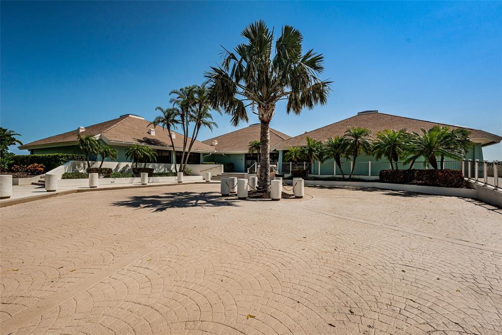 9495 Blind Pass Road, Unit 205 St. Pete Beach, FL 33706 - Photo 49 of 71 a row of palm trees and a swimming pool in the backyard of house