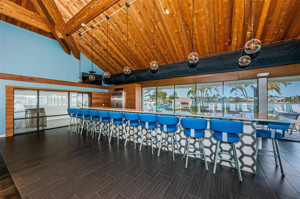 9495 Blind Pass Road, Unit 205 St. Pete Beach, FL 33706 - Photo 52 of 71 a view of a patio with table and chairs with wooden floor and fence