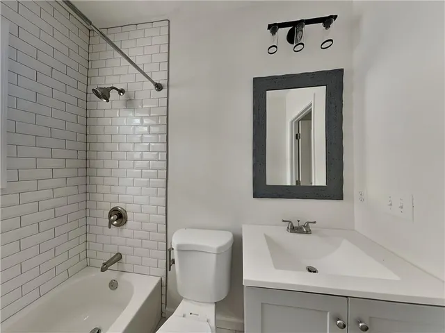 a bathroom with a sink mirror bathtub and toilet