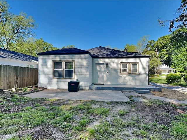 a view of a house with backyard and a tree
