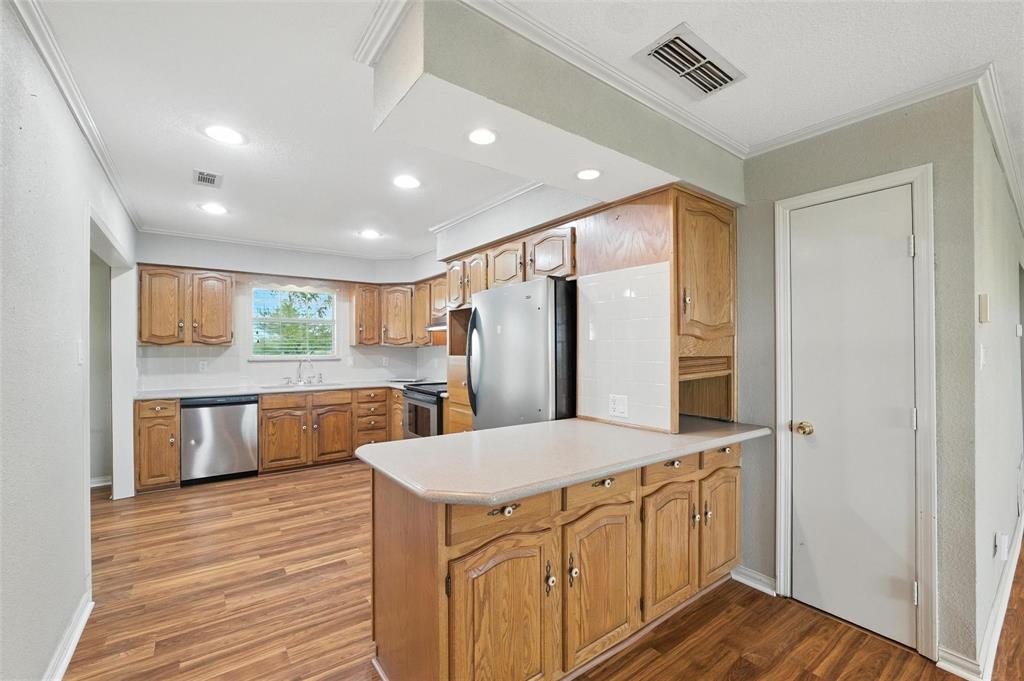 358 Wright Road Waxahachie, TX 75167 - Photo 20 of 38 a kitchen with stainless steel appliances kitchen island granite countertop a refrigerator a sink and wooden floors