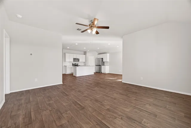 a view of empty room with wooden floor and windows