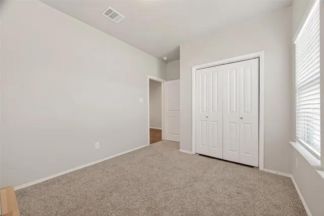 an empty room with windows and closet