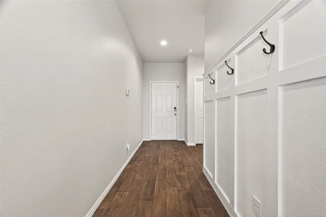 a view of a hallway with wooden floor and staircase