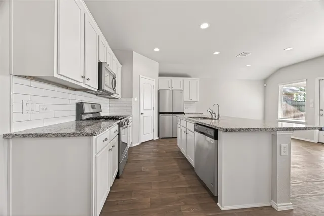 a kitchen with stainless steel appliances granite countertop a sink and cabinets