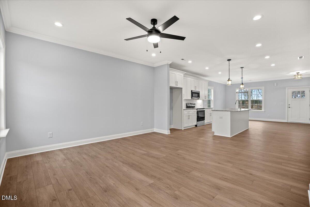 1300 Nick Coley Road Whitakers, NC 27891 - Photo 20 of 47 a view of an empty room with wooden floor and a kitchen