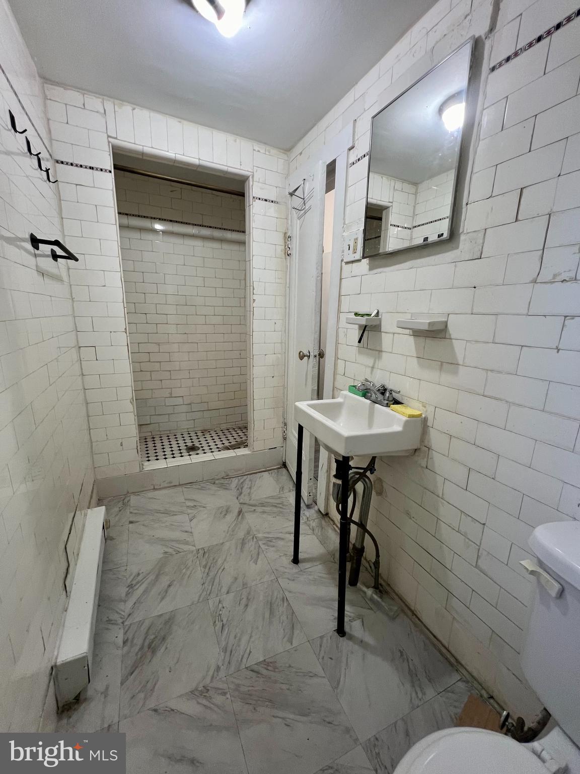 3140 North Broad Street, Unit 2F Philadelphia, PA 19132 - Photo 6 of 7 a bathroom with a sink toilet and shower