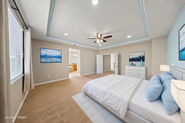 a spacious bedroom with a large bed and a chandelier