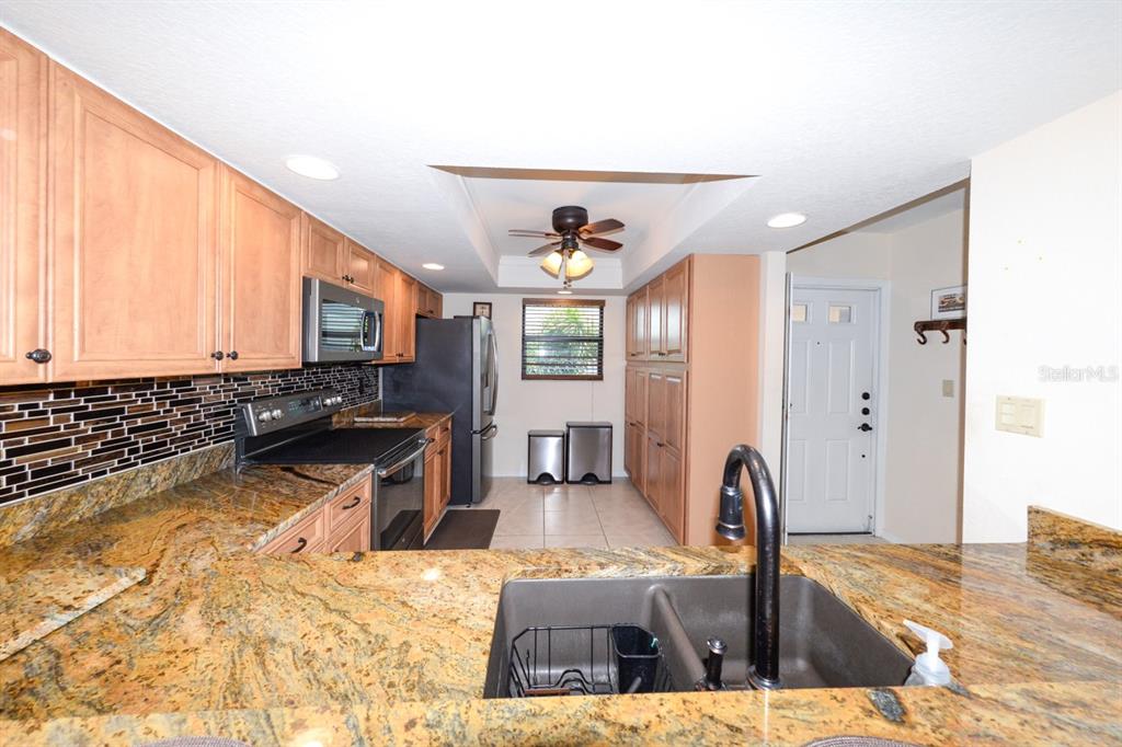 335 Coldeway Drive, Unit F21 Punta Gorda, FL 33950 - Photo 2 of 45 a living room with stainless steel appliances kitchen island granite countertop a refrigerator a stove a sink dishwasher and white cabinets with wooden floor